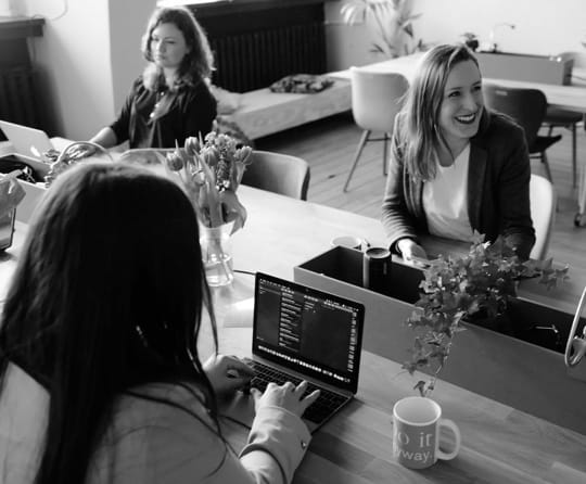 women sitting at table collaborating